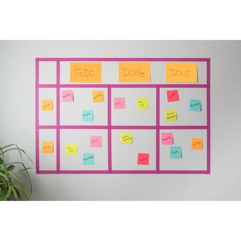 Seinälle kiinnitetty Kanban-taulu näyttää värikkäitä 3M Deutschland GmbH Post-it® Super Sticky Notes -muistiinpanoja (76x127mm, 90 arkkia, 100% PEFC), jotka on merkitty tehtävillä ja nimillä sarakkeissa "Tehtävä", "Työn alla" ja "Valmis". Alavasemmassa kulmassa on vihreä kasvi.