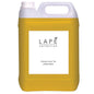Suuri keltainen muovikanisteri (5 l), jossa on valkoinen kierrekorkki ja kahva, Diversey Deutschland GmbH & Co. OHG:ltä. Etiketti: "LAPĖ Collection Oriental Lemon Tea Hand Wash, käsisaippua itämaisella tuoksulla.