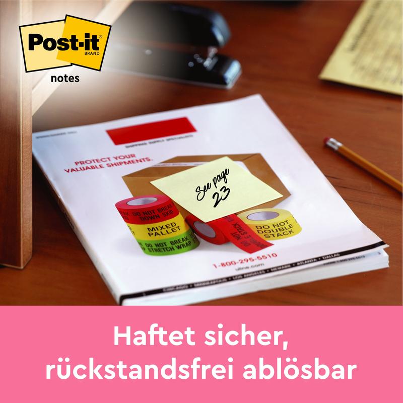 3M Deutschland GmbH:n keltainen Post-it® Note, 76 mm x 127 mm, jossa lukee "Katso sivu 23", on kiinnitetty asiakirjaan työpöydällä. Alhaalla lukee: "Kiinnittyy varmasti, irtoaa jäämättä jälkiä.