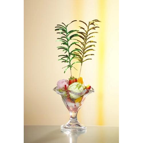 Lasinen jälkiruokakuppi, jossa on värikästä jäätelöä, hedelmäpaloja ja kaksi värikästä PAPSTAR 144 koriste-tikkua PAPSTAR GmbH:lta, kaikki pehmeästi valaistun taustan edessä.