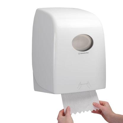 Joku vetää Scott® ESSENTIAL™ käsipyyherullan arkkia valkoisesta, seinään kiinnitetystä annostelijasta Kimberly-Clark GmbH:lta, jonka läpinäkyvä ikkuna paljastaa sisällä olevat käsipyyherullat.