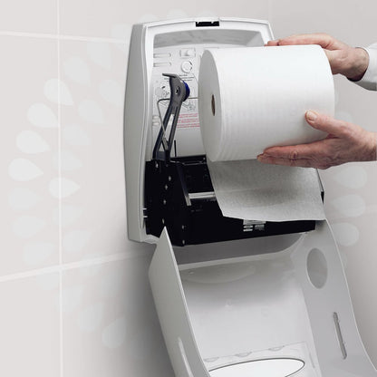 Henkilö asettaa Kimberly-Clark GmbH:n Kleenex® Ultra™ -käsipyyherullan valkoiseen, avoimeen seinäannostelijaan wc:ssä varmistaakseen hygieenisen käsien kuivaamisen. Annostelijan kannessa on ohje painettuna.