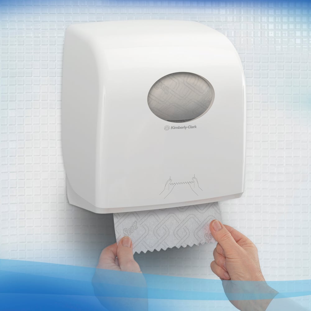 Henkilö vetää Scott® CONTROL EXTRA STRONG -käsipyyhkeitä seinään kiinnitetystä valkoisesta annostelijasta Kimberly-Clark GmbH:lta, joka on valkoisten, kuvioitujen laattojen päällä. Rulla-annostelijan etupuolella on yksinkertainen käyttöohje.