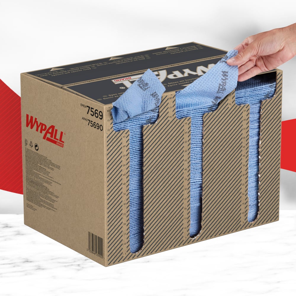 Käsi vetää sinisen WypAll® ForceMax -pyyhkeen (33,50 x 34,50 cm) ruskeasta laatikosta, jossa on kolme aukkoa etupuolella. Esille tulee Kimberly-Clark GmbH:n kestäviä pyyhkeitä tehokkaaseen teolliseen puhdistukseen. Laatikko sisältää 480 neljään osaan taitettua pyyhettä.
