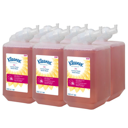 Kuusi 1 litran Kleenex® Botanics™ Luxury Foam Hand Wash -kasettia Kimberly-Clark GmbH:lta, jokainen täytetty punaisella nesteellä ja kasvipohjaisilla ainesosilla, on järjestetty siististi kahteen kolmen rivin ryhmään. Jokainen kasetti annostelee vaahtoa ja toimitetaan kuuden kappaleen laatikossa.