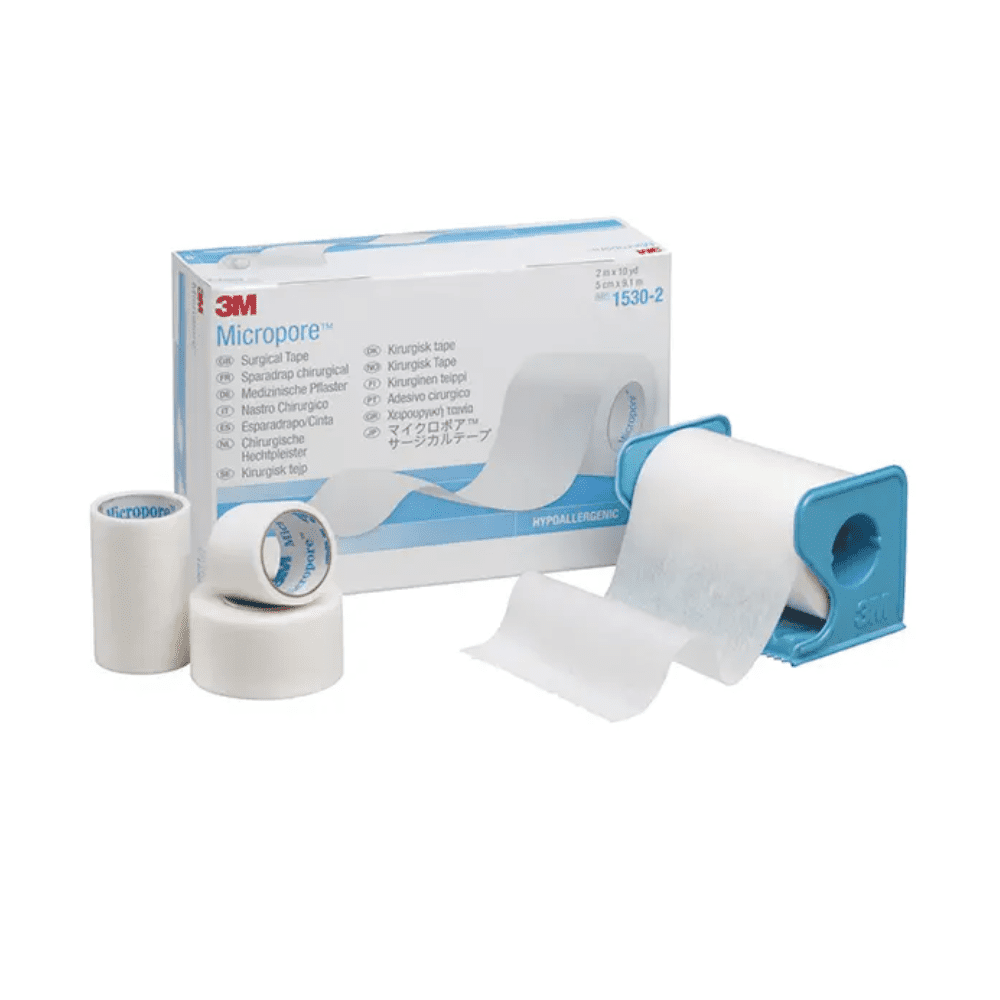 Kuva näyttää 3M Healthcare Germany GmbH:n 3M-Medica Micropore -laastarin, ihonvärinen – 12 kappaletta | Pakkaus (12 kappaletta) -laatikko, jossa on erikokoisia laastareita edessä. Yksi laastarirulla on sinisessä annostelijassa, kun taas kaksi muuta laastarirullaa ja pienempi rulla seisovat pystyasennossa laatikon vieressä. Hypoallergeeninen laastari on valkoinen.
