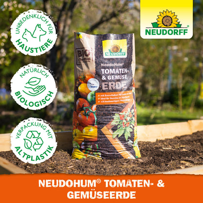 Eine Tüte NeudoHum Tomaten- & GemüseErde aus dem Neudorff Shop steht auf einem Gartenbeet, mit Symbolen für Tierschutz, Bio-Qualität und Verpackung aus recyceltem Kunststoff. Das Neudorff-Logo befindet sich in der oberen rechten Ecke.
