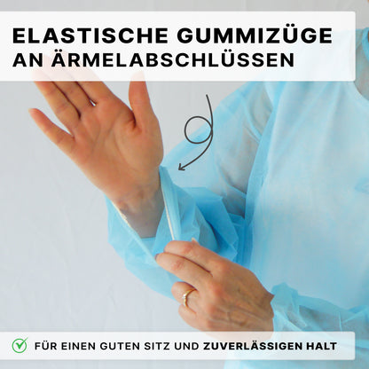 Henkilö näyttää vaaleansinisen ARNOMED PROTECT PP-SCHUTZKITTEL kertakäyttöisen suojatakin PP-kuitukankaasta ARNOWA GmbH:lta joustavaa mansettia. Saksankielinen teksti korostaa turvallista istuvuutta. Alareunassa näkyy valintamerkki ja selitys.