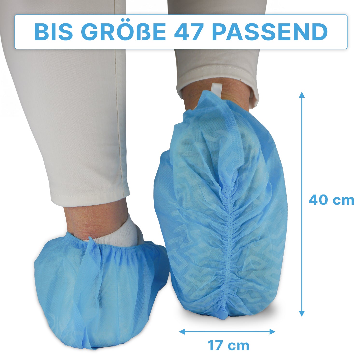 Eine Person trägt blaue ARNOMED ABS Schuhüberzieher der ARNOWA GmbH über einer weißen Hose; diese rutschfesten Einweg-Schuhüberzieher passen bis Größe 47 und messen ca. 40×17 cm, wie durch Pfeile dargestellt. Packung: 100 Stück.