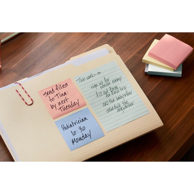 Puupöydällä on kansio, jossa on sinisiä, vaaleanpunaisia ja keltaisia Post-it® Recycling Z-Notes (76 mm x 76 mm, 100 arkkia/lohko, 100 % PEFC) 3M Deutschland GmbH:lta, joissa on käsinkirjoitettuja muistutuksia. Värikkäät, käyttämättömät laput ovat pinottu viereen.