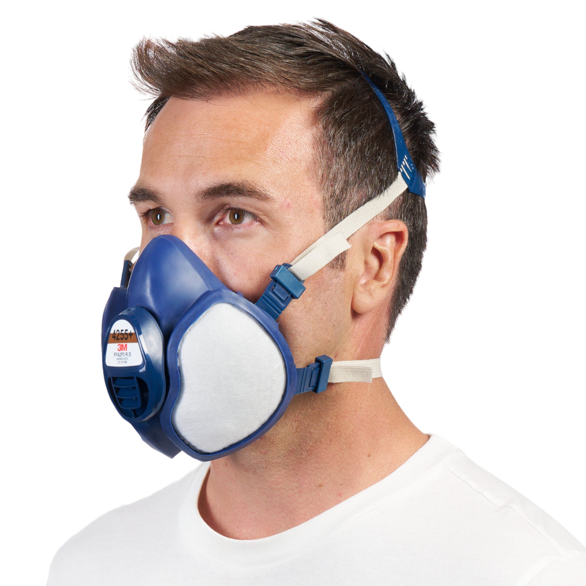 Ein Mann mit kurzen braunen Haaren trägt eine blau-weiße 3M™ Atemschutzmaske mit integrierten Filtern von 3M Deutschland GmbH mit verstellbaren Trägern, dargestellt vor einem schlichten weißen Hintergrund.