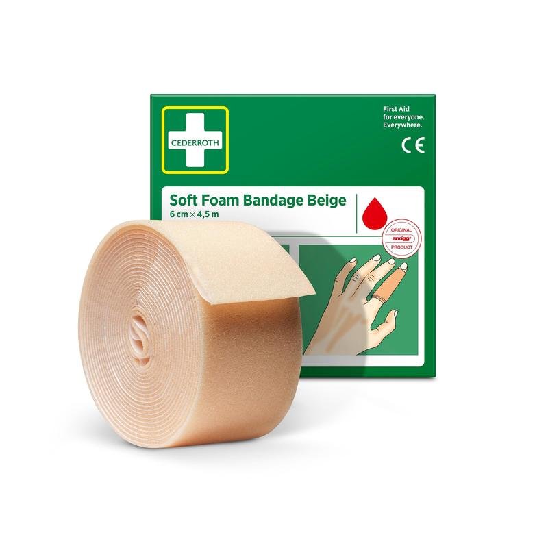 Orkla Wound Care AB:n Cederroth pehmeä vaahtosidos beige 6 cm x 4,5 m -rulla seisoo vihreä-valkoisen laatikon edessä, jossa on käsi sidotulla sormella ja tuotteen nimi.