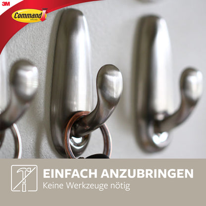 Nahaufnahme des Command™ Metallhakens "klassisch" von 3M Deutschland GmbH mit einem Schlüsselring an einem Haken. Inklusive Logo und deutschem Text: "Einfach anzubringen. Keine Werkzeuge nötig." (Einfach anzubringen. Keine Werkzeuge nötig).