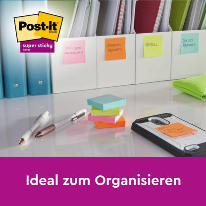 Post-it® Super Sticky Notes -muistilaput (76 mm x 76 mm, 90 arkkia/lohko, 100% PEFC) 3M Deutschland GmbH:lta ovat työpöydällä yhdessä kynien, älypuhelimen ja kansioiden kanssa; kuvassa näkyy teksti "Ihanteellinen järjestelyyn" ja Post-it-logo.