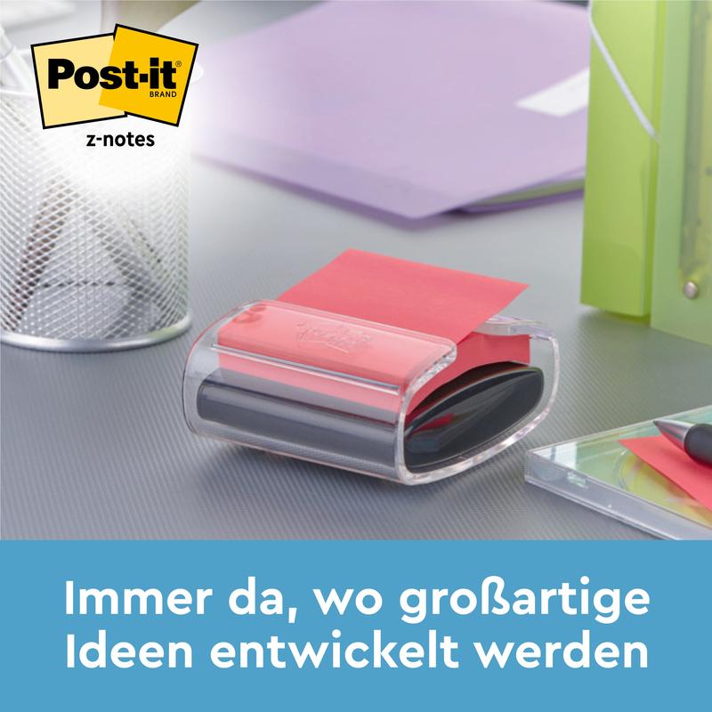Post-it® Z-Notes -annostelija karhun muodossa, valkoinen, sinisten Super Sticky Z-Notes -muistilappujen (76 x 76 mm) kanssa 3M:ltä seisoo työpöydällä kynien ja kansioiden vieressä. Teksti alhaalla: "Aina siellä, missä loistavia ideoita kehitetään."
