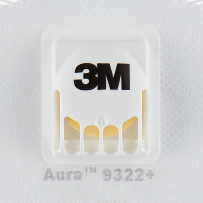 Die Nahaufnahme einer weißen 3M™ Aura™ Comfort Cool Flow™ Partikelmaske 9322+, FFP2, mit Ventil von 3M Deutschland GmbH zeigt das schwarze 3M-Logo, das belüftete Kunststoffventil und einen Teil der Modellbezeichnung unterhalb des Ventils.