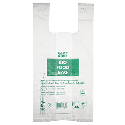 Die 100 Hemdchen-Tragetaschen der PAPSTAR GmbH sind transparente, biologisch abbaubare Bio-Folie-Knotenbeutel auf einer Rolle mit grünem „PAP STAR BIO FOOD BAG“-Text und mehrsprachigen Informationen zur Kompostierbarkeit und zu nachwachsenden Rohstoffen.