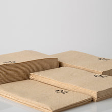 Neljä pinoa PAPSTAR lautasliinoja, 3-kerroksinen, 33x33 cm, luonnonvärinen, kierrätetystä paperista (100 kappaletta) PAPSTAR GmbH:lta, valkoisella pinnalla. Jokaisessa kierrätetyssä lautasliinassa on pieni musta kierrätyssymboli kulmassa.