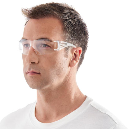 Mies, joka käyttää 3M Deutschland GmbH:n 3M™ SecureFit™ 200 -suojalaseja ja yksinkertaista valkoista T-paitaa, katsoo hieman oikealle valkoisella taustalla.