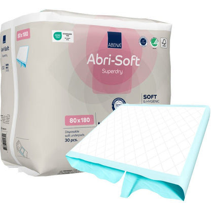 Pakkaus Abena Re-Seller GmbH:n kertakäyttöisiä Abri-Soft Superdry -alustoja, 80x180 cm, sisältää 30 kertakäyttöistä alustaa. Yksi alusta on osittain avattu edestä. Pakkaus korostaa tärkeimpiä ominaisuuksia - ihanteellinen inkontinenssin hoitoon.