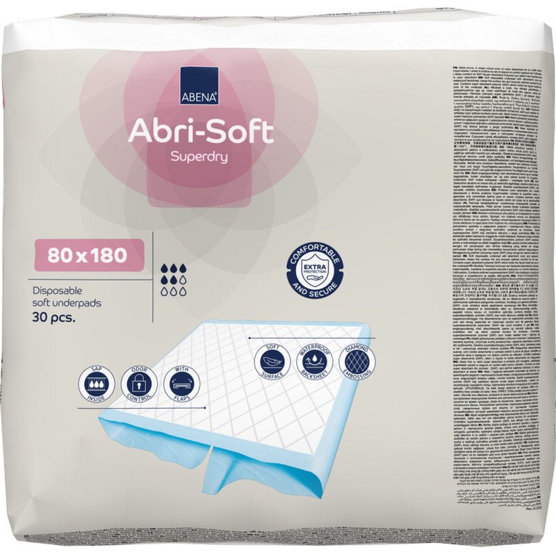Pakkaus, jossa on 30 Abri-Soft Superdry -kertakäyttöalustaa (80x180 cm) Abena Re-Seller GmbH:lta. Pakkaus korostaa käyttöä inkontinenssiin, näyttää koon ja esittää kuvia pehmeästä alustarakenteesta.
