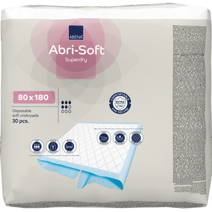 Pakkaus, jossa on 30 Abri-Soft Superdry -kertakäyttöalustaa (80x180 cm) Abena Re-Seller GmbH:lta. Pakkaus korostaa käyttöä inkontinenssiin, näyttää koon ja esittää kuvia pehmeästä alustarakenteesta.