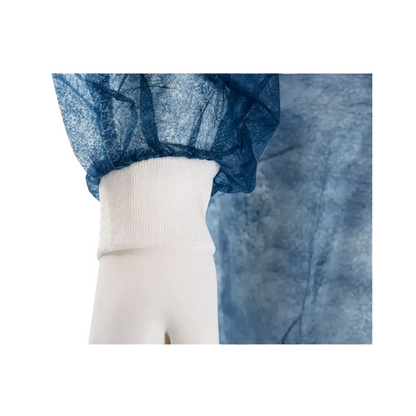 Lähikuva mallinuken kädestä, joka kantaa sinistä, puoliksi läpikuultavaa vaatetta, jossa on valkoinen elastinen resori. Tämä AMPri MED-COMFORT PP kertakäyttöinen vierailutakki, jossa on resorit ja jonka on valmistanut AMPri Handelsgesellschaft mbH, on valmistettu rypistyneestä polypropeenimateriaalista ja tarjoaa mukavan istuvuuden ranteen ympärille.