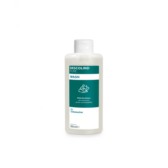 Dr. Schumacher GmbH:n valmistama valkoinen muovipullo, jossa on Dr. Schumacher Descolind Pure Wash -pesulotionia (500 ml) ja vihreä-valkoinen etiketti, seisoo yksinkertaisen vaaleanharmaan taustan edessä. Tämä ihon pH-tasapainoinen, hajusteeton pesulotion sopii erinomaisesti herkälle iholle.