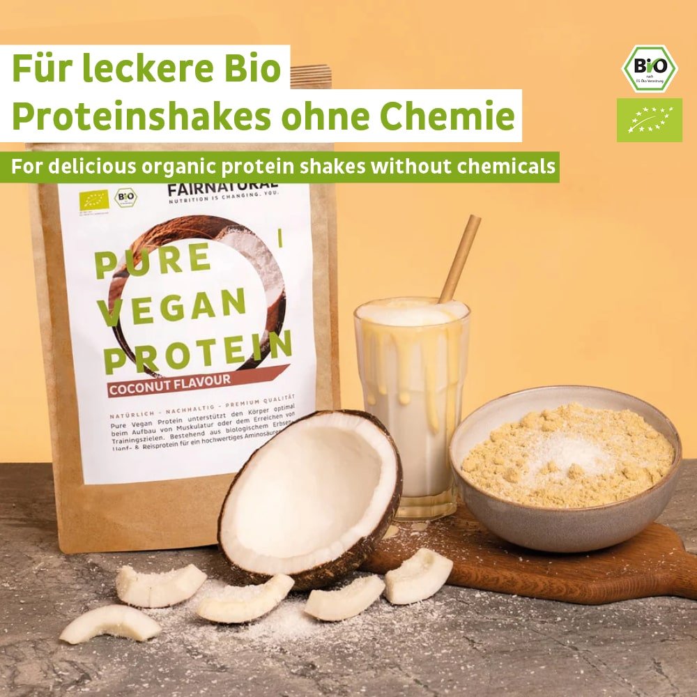 Fairnatural® luomuvegaanista proteiinijauhetta kookoksella ilman soijaa sisältävä pakkaus, lasillinen vegaanista proteiinipirtelöä, mittalusikallinen jauhetta ja kookospähkinän paloja on aseteltu vaalealle pinnalle. Etiketti korostaa luomuproteiinia, täydellinen lihasten kasvattamiseen tai dieettiin.