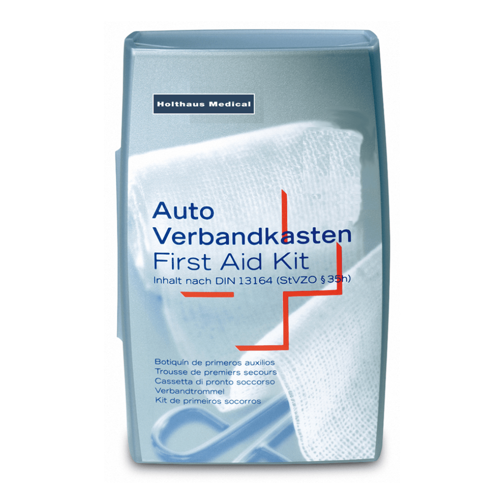 Holthaus Medical GmbH & Co. KG:n hopeinen Holthaus-ensiapupakkaus. Kannen teksti on monikielinen, ja siinä lukee ”Auto Verbandkasten / Erste-Hilfe-Kasten” (auton ensiapulaukku / ensiapupakkaus), ja siinä mainitaan, että pakkaus täyttää standardin DIN 13164 (StVZO §35h) vaatimukset. Taustalla näkyy valkoinen lääketieteellinen side, joka sopii erinomaisesti lääketieteellisiin hätätilanteisiin.
