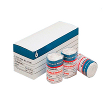 Valkoisessa laatikossa, jossa on teksti "Holthaus YPSIDAL Nabelbinde" ja sinisiä ja valkoisia raitoja, on rulla 6 cm x 2 m kokoista lääketieteellistä sidettä, joka on valmistettu 100 % puuvillasta. Laatikon edessä on kolme rullaa elastista sidettä "Mollelast Medical", jossa on merkintä "8 cm".