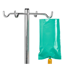 Esitetty on metallinen tippateline, jossa on useita koukkuja, joista yhdessä on osittain näkyvä B. Braun valosuojus Ecoflac® plus Green Bagille. Pidike on yksinkertaisen valkoinen, ihanteellinen valoherkkien liuosten lääketieteelliseen käyttöön.