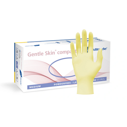 Näytillä on laatikko keskikokoisia, jauheettomia lääketieteellisiä käsineitä Meditrade Gentle Skin® Latexhandschuhe compact+ kertakäyttöiset käsineet, ja edessä on keltainen lateksinen kertakäyttökäsine.
