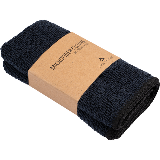Ein Set von zwei schwarzen ENA Living Mikrofasertüchern (30x30 cm) von Abena Re-Seller GmbH, jeweils gefaltet mit einem braunen Etikett mit der Aufschrift "Microfiber Cloths 30 x 30 cm" und einem minimalistischen Logo - ideal für die Verwendung als Reinigungstücher im Haushalt.