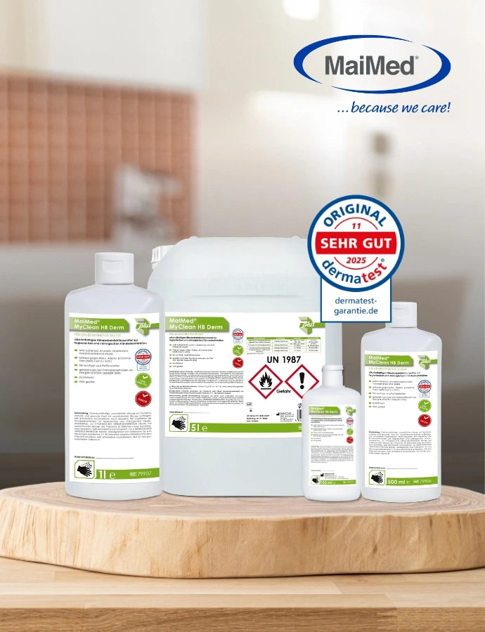 MaiMed Desinfektionsmittel in verschiedenen Gebindegrößen (Flaschen und Kanister) stehen auf einer runden Holzplatte vor unscharfem Innenraum-Hintergrund. Oben ist das MaiMed-Logo mit dem Slogan „because we care!“ zu sehen, daneben ein Dermatest-Siegel „SEHR GUT 2025“.