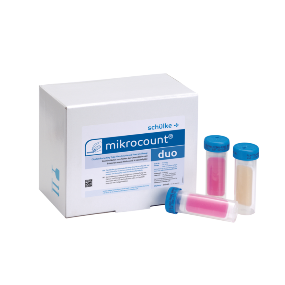 Kuva näyttää laatikon, jossa on merkintä „Schülke mikrocount® duo, mikrobien indikaattori | Pakkaus (20 kappaletta)“ merkiltä „Schülke & Mayr GmbH“ kolmen värikoodatun putken vieressä, joissa on siniset korkit. Putket sisältävät vaaleanpunaisia ja beigejä aineita, joita käytetään mikro-organismien, mukaan lukien hiivojen ja homeiden, havaitsemiseen pinnoilla ja nesteissä.