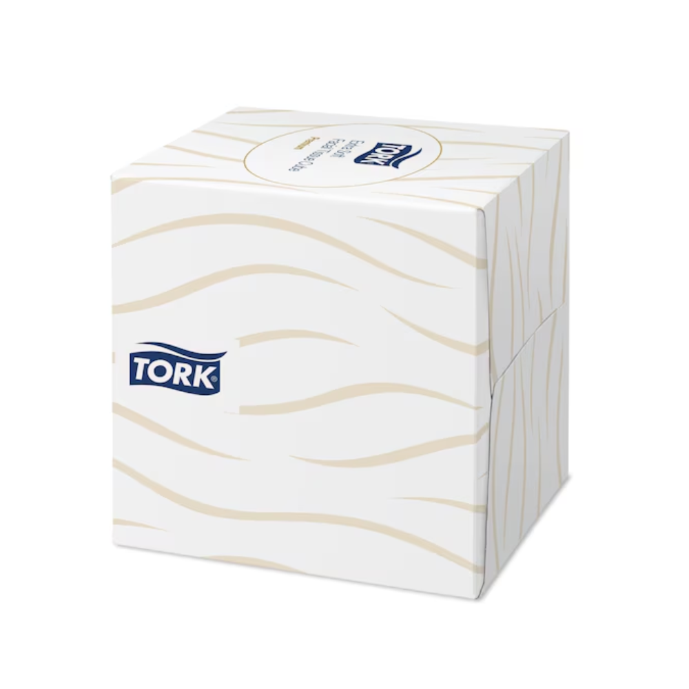 Valkoinen Tork 140278 Tork extra pehmeä nenäliina-annostelukuutio, jossa on aaltoileva beige kuvio ja TORK-logo sivussa.