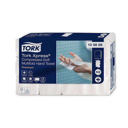 Pakkaus Tork Xpress® Puristettuja Pehmeitä Monikerroksisia Käsipyyhkeitä Premium H2 2-kerroksinen, merkitty Premiumiksi, TORK – Essity Professional Hygiene Germany GmbH. Pakkaus näyttää kuvan kädestä, joka pitää käsipyyhettä, ja korostaa tuotteen ominaisuuksia, kuten hygieniaa, imukykyä ja yksittäislehtien annostelua sinivalkoisessa suunnittelussa.