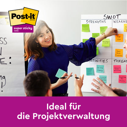 Eine Frau steht vor einem Whiteboard, das mit Post-It® Super Sticky Notes (47,6 x 47,6 mm, verschiedene Farben, 45 Blatt/Block, 4 Blöcke) der 3M Deutschland GmbH gefüllt ist, und diskutiert über Projektmanagement in deutscher Sprache. Das PEFC-zertifizierte Logo ist sichtbar.