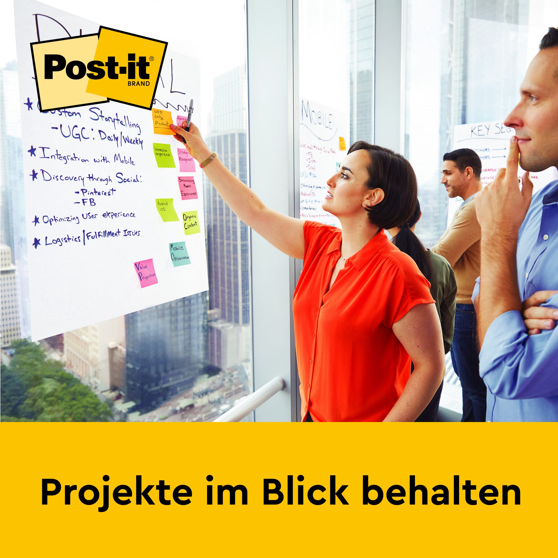 Eine Frau schreibt auf einem Post-it® Super Sticky Mini Meeting Chart (38 x 45,7 cm, 20 Blatt) von 3M Deutschland GmbH, an dem Post-its befestigt sind, während drei Kollegen in einem modernen Büro zusehen. Text: "Projekte im Blick behalten.