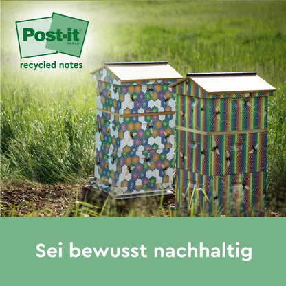 Kaksi värikästä mehiläispesää seisoo pellon ruohossa. 3M Post-it® Recycling Z-Notes (76 x 76 mm, 100 % PEFC) -logo näkyy vasemmassa yläkulmassa. Alareunassa on saksankielinen teksti: "Ole tietoinen kestävyydestä."