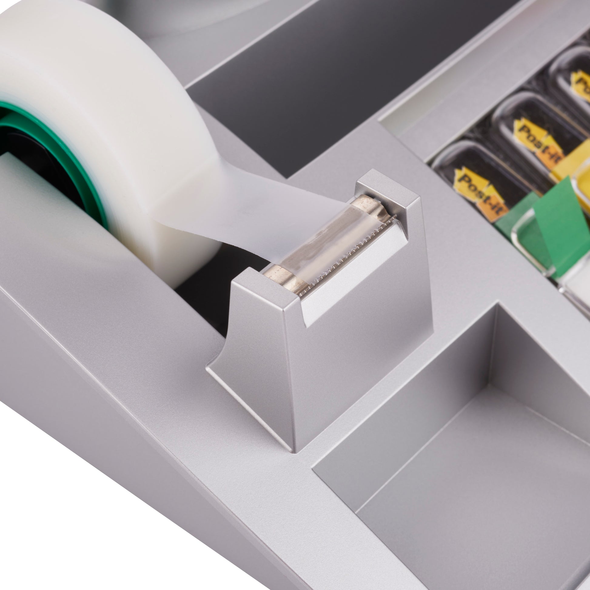 Eine Nahaufnahme des 3M Deutschland GmbH Post-it® Tisch-Organizer mit Post-it® Notes, Index und Scotch® Magic™ Klebeband (1 Stück), die den Klebebandabroller mit gezackter Kante und die angrenzenden Tisch-Organizerfächer zeigt.