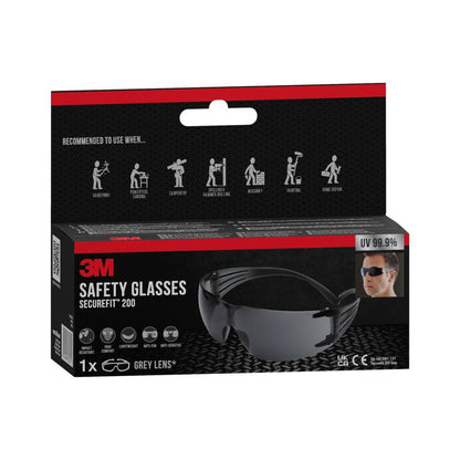 Kuvassa on laatikko 3M™ SecureFit™ suojalaseja 200, 3M Deutschland GmbH. Pakkaus korostaa 99,9 % UV-suojaa ja näyttää symbolit käytölle puutarhassa, puusepän töissä ja laboratoriossa.