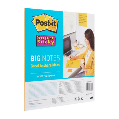 Henkilö kirjoittaa työpöydällään 3M Deutschland GmbH:n Post-it® Super Sticky Big Notes BN11-EU -lohkoon (279x279mm, keltainen, 30 arkkia, 100% PEFC). Pakkaus brändäyksineen ja tietoineen näkyy kannettavan tietokoneen ja muistikirjan vieressä.
