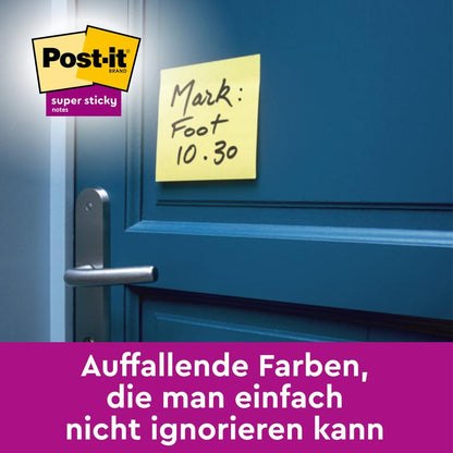 Keltainen Post-it® Super Sticky Note (101 x 101 mm, viivoitettu, 45 arkkia, 100% PEFC) 3M Deutschland GmbH:lta, jossa on teksti "Mark: Foot 10.30", sijaitsee sinisellä ovella lähellä kahvaa. Saksalainen teksti kehuu sen huomiota herättäviä, vaikeasti ohitettavia värejä.