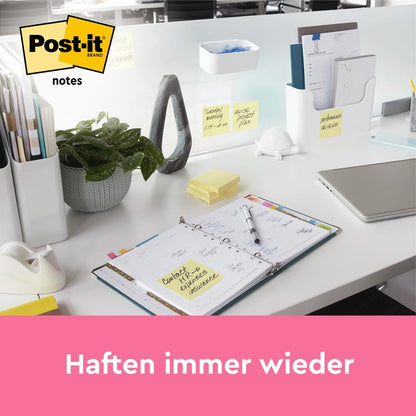 Siisti työpöytä näyttää kirjoitustarvikkeita, kasvin, avoimen suunnittelijan ja keltaiset Post-it® Notes (76 mm x 127 mm, 100 arkkia/lohko) 3M Deutschland GmbH:lta papereilla ja lasiväliseinällä. Post-it-logo ja "Kiinnittyy yhä uudelleen" ovat kuvattuna.