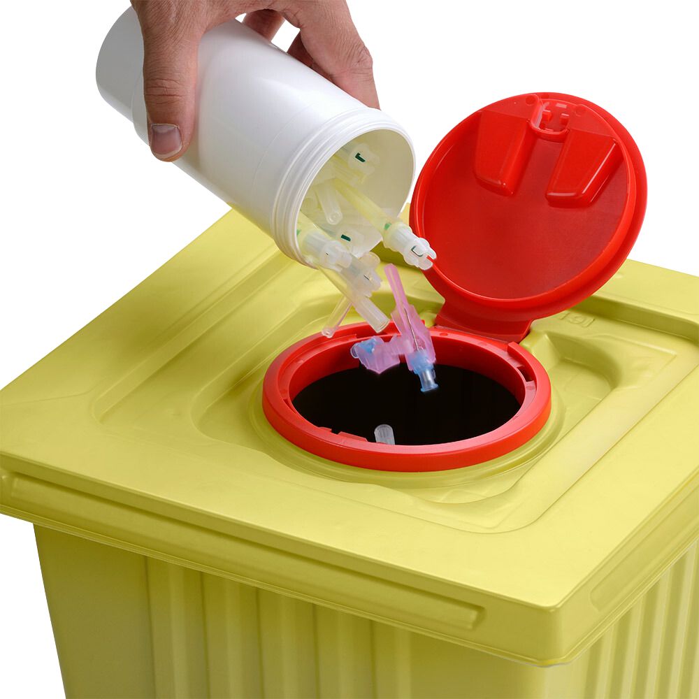 Käsi hävittää käytettyjä ruiskun kärkiä valkoisesta Helmut Schwarz GmbH melijekt -kierrätysastiasta 12 L keltaiseen lääkejätteen astiaan, jossa on punainen kansi, varmistaen näin asianmukaisen hävittämisen.