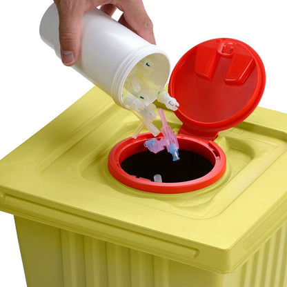 Käsi hävittää käytettyjä ruiskun kärkiä valkoisesta Helmut Schwarz GmbH melijekt -kierrätysastiasta 12 L keltaiseen lääkejätteen astiaan, jossa on punainen kansi, varmistaen näin asianmukaisen hävittämisen.